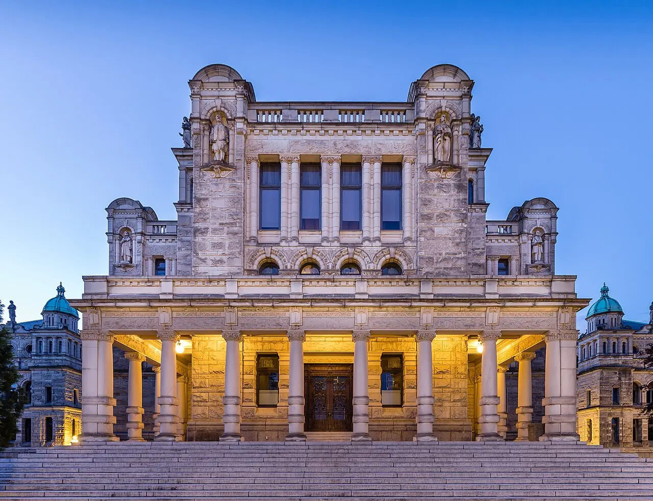 The British Columbia Parliament Buildings in Victoria, photographed at dusk with the stone facade illuminated