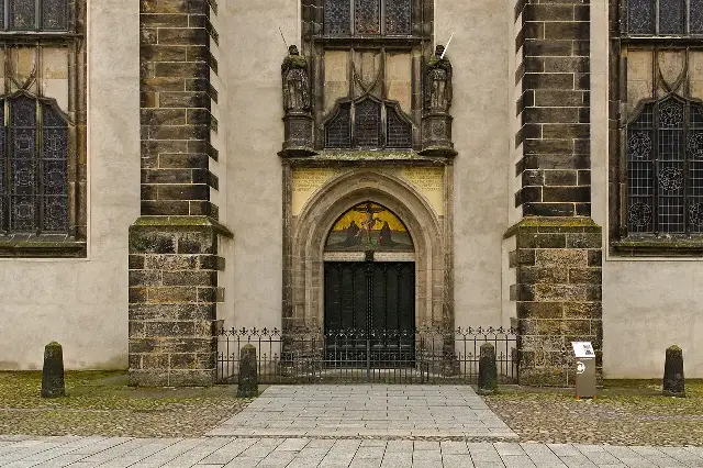 The bronze Theses Door of Wittenberg's Castle Church, inscribed with the text of Luther's 95 Theses, topped by a mosaic of the crucifixion