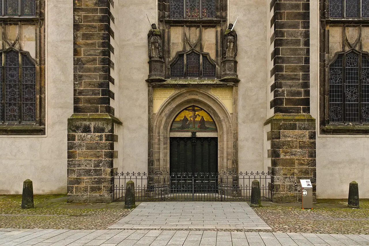 The bronze Theses Door of Wittenberg's Castle Church, inscribed with the text of Luther's 95 Theses, topped by a mosaic of the crucifixion