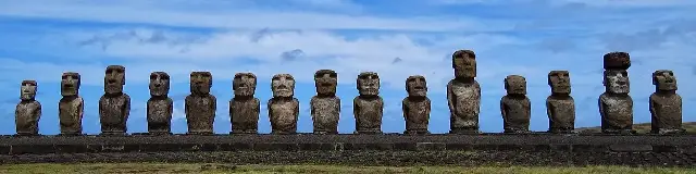 Fifteen restored moai stand in a row atop the ahu platform at Tongariki, Easter Island.