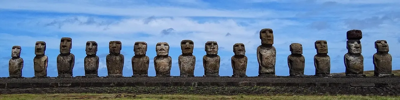 Fifteen restored moai stand in a row atop the ahu platform at Tongariki, Easter Island.