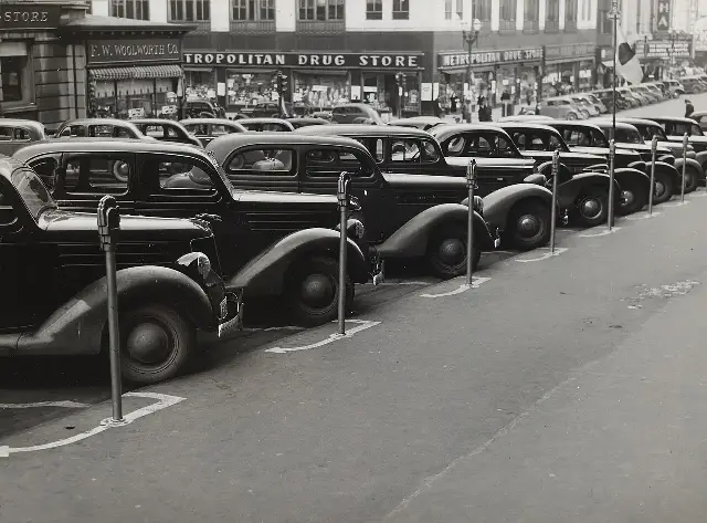 A 1938 photograph of cars parked diagonally along a row of early parking meters on a city street in Omaha, Nebraska.