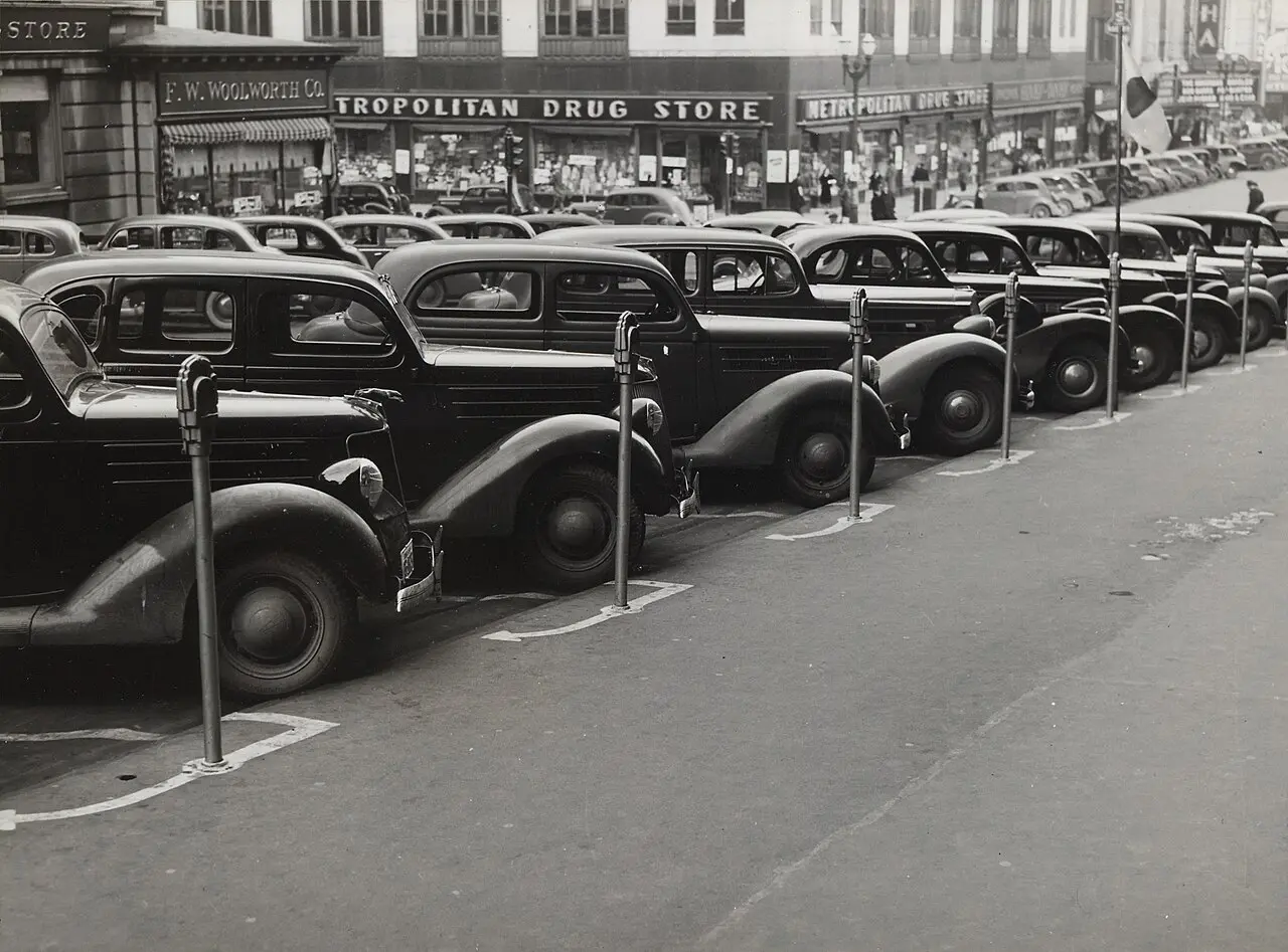 A 1938 photograph of cars parked diagonally along a row of early parking meters on a city street in Omaha, Nebraska.