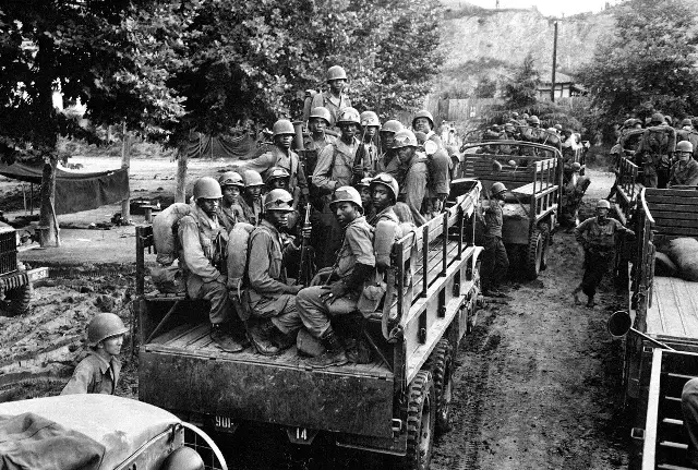 Soldiers of the 24th Infantry Regiment, an all-Black unit, riding in Army trucks in Korea in 1950.