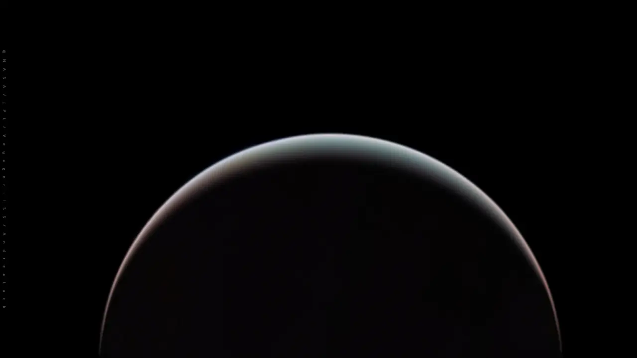 A thin crescent of Uranus glowing pale blue-green against black space, processed from Voyager 2 images taken during the 1986 flyby.