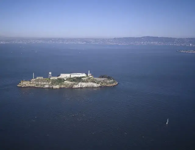 Aerial view of Alcatraz Island in San Francisco Bay, showing the prison buildings, lighthouse, and water tower.