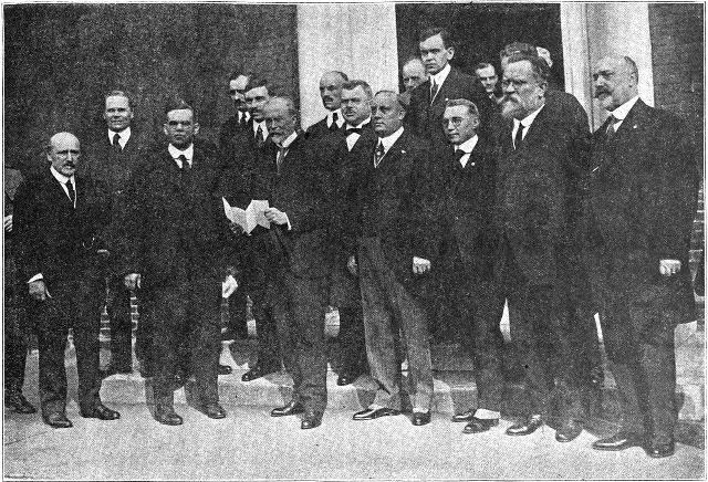 Tomáš Garrigue Masaryk standing with a group of men on the steps of a building in Philadelphia in 1918, holding a document