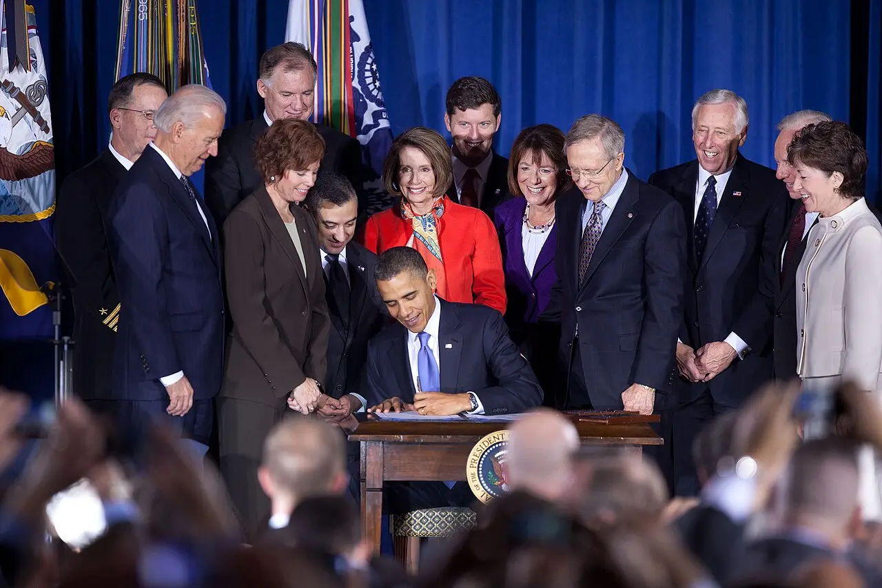 President Barack Obama signing the Don't Ask, Don't Tell repeal act on December 22, 2010, surrounded by officials and veterans