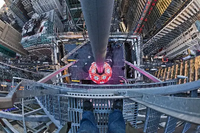 The Times Square New Year's Eve Ball glowing above One Times Square, seen from the rooftop