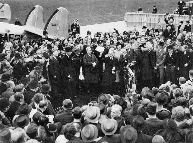 Neville Chamberlain holding up the signed Munich Agreement before a crowd at Heston Aerodrome on September 30, 1938.