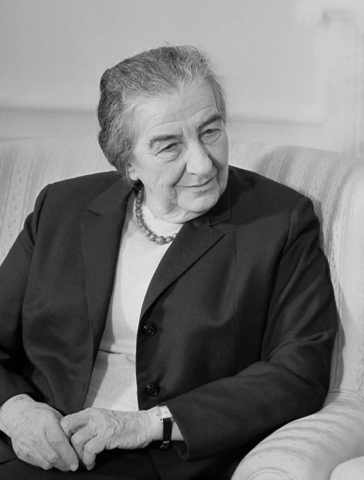 Black-and-white portrait of Golda Meir seated and smiling, photographed in the 1960s.
