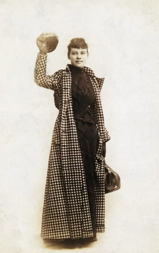 An 1889 portrait of journalist Nellie Bly in her traveling cloak, waving her cap — the outfit she wore on her round-the-world journey.