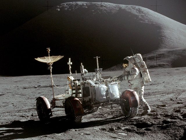 Astronaut Jim Irwin with the Lunar Roving Vehicle at the end of Apollo 15's first moonwalk, photographed by commander David Scott, with Mount Hadley behind.