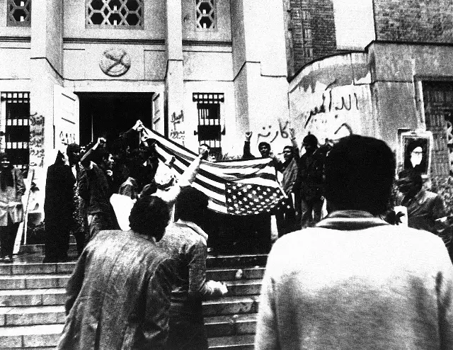 Iranian demonstrators outside the U.S. Embassy in Tehran in November 1979, holding up a captured American flag.