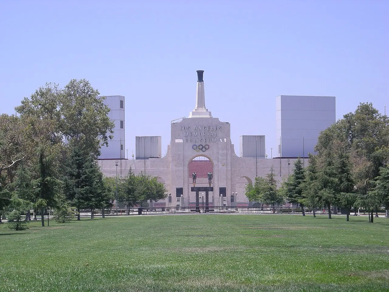 The Los Angeles Memorial Coliseum peristyle with its Olympic rings and twin towers, seen from the park in front