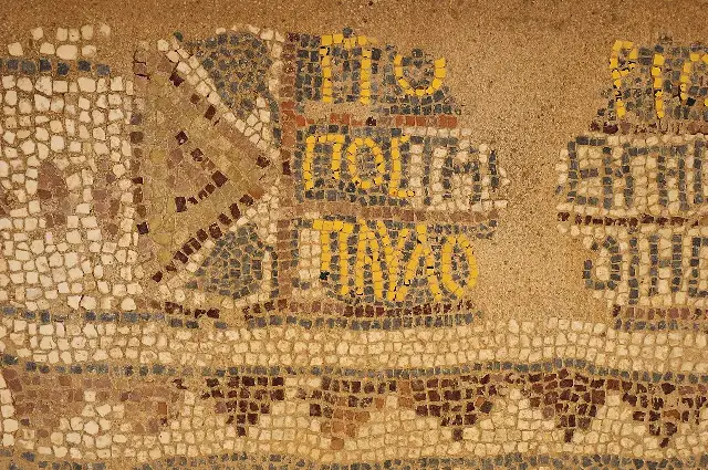 Close-up of an ancient mosaic floor at the archaeological site of Philippi, Greece, showing colored stone tesserae.