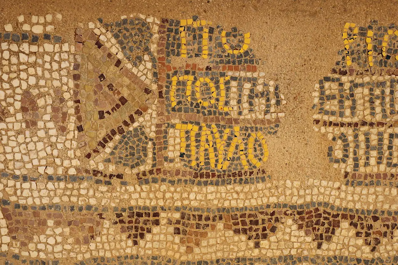 Close-up of an ancient mosaic floor at the archaeological site of Philippi, Greece, showing colored stone tesserae.