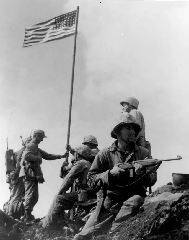 U.S. Marines raising the first American flag atop Mount Suribachi, Iwo Jima, on February 23, 1945