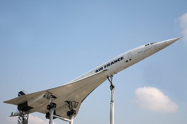 An Air France Concorde displayed on pylons at an aviation museum.