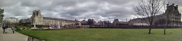 A panoramic view of the Louvre Museum complex in Paris, seen from the Tuileries Garden.