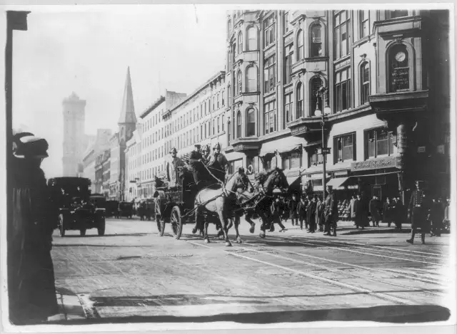 1911 photograph of horse-drawn fire engines racing through a New York City street toward the Triangle Shirtwaist factory fire.