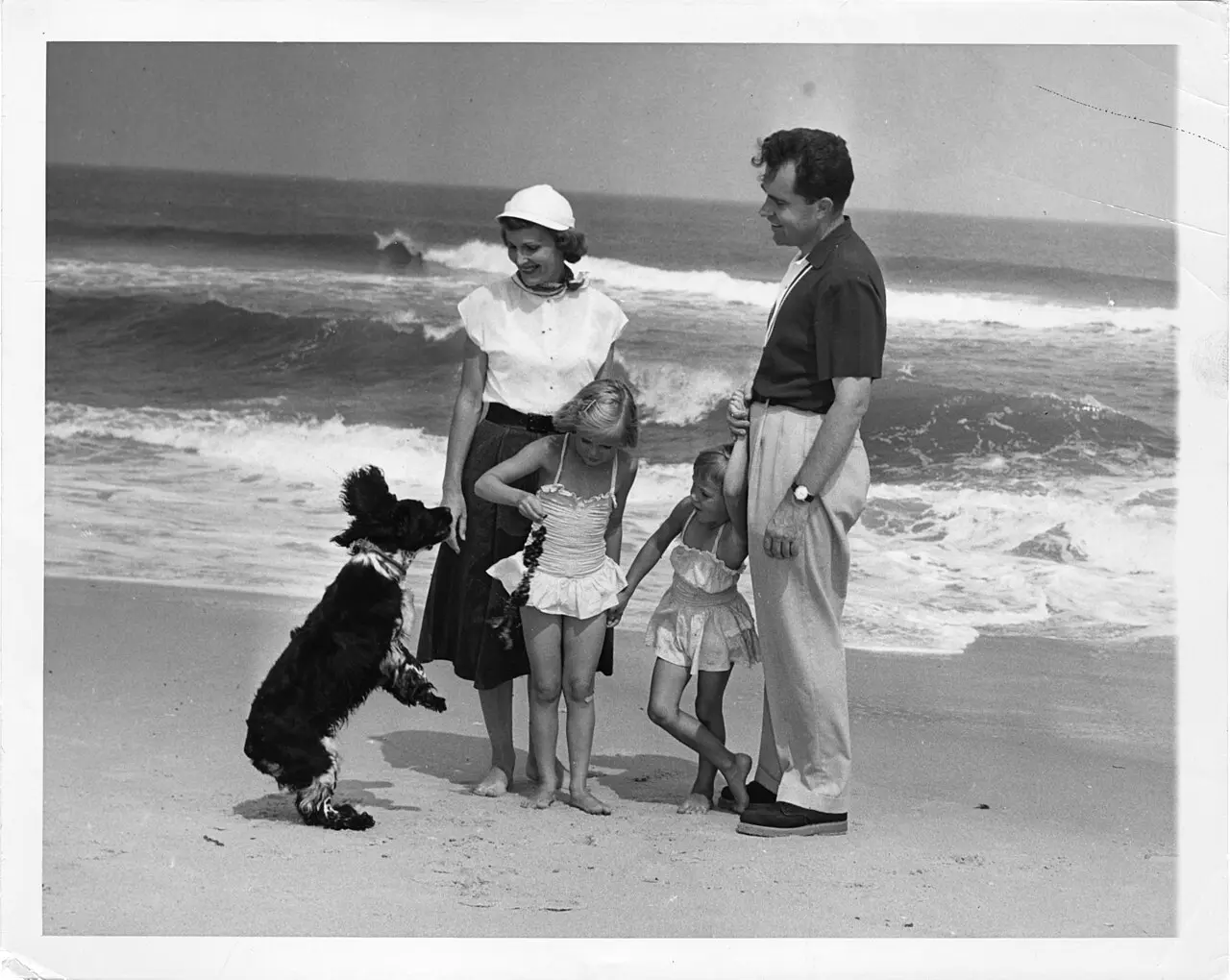 Richard Nixon with his wife Pat, their daughters, and Checkers the cocker spaniel on a New Jersey beach