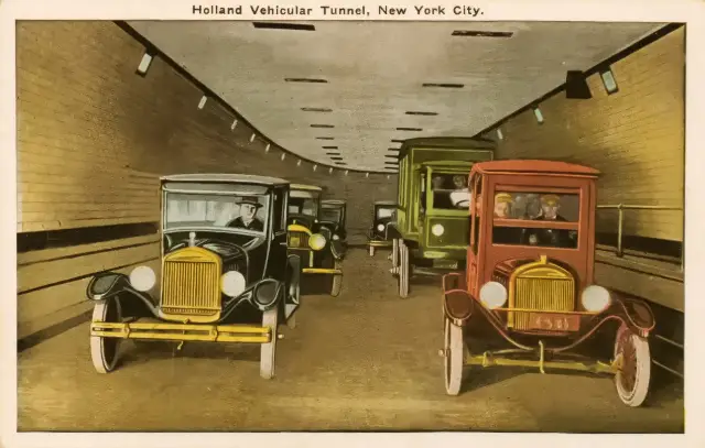 A 1927-era colorized postcard showing automobiles driving through the tiled interior of the Holland Tunnel under the Hudson River.