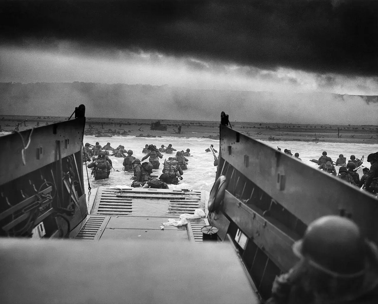 U.S. Army troops of Company A, 16th Infantry wade ashore from a Coast Guard landing craft onto Omaha Beach on the morning of June 6, 1944, in Robert F. Sargent's photograph 'Into the Jaws of Death.'