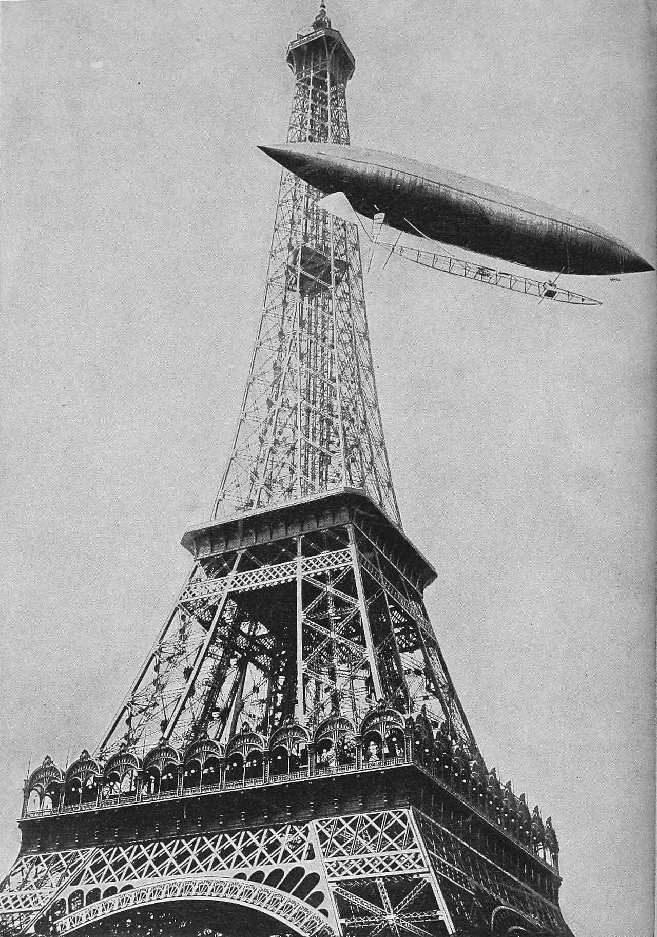 Santos-Dumont's airship No. 5 circling the Eiffel Tower above Paris in July 1901, photographed from below against a bright sky.