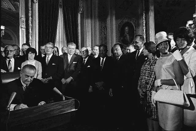 President Lyndon B. Johnson signs the Voting Rights Act of 1965 as Martin Luther King Jr. and other civil rights leaders look on, August 6, 1965.