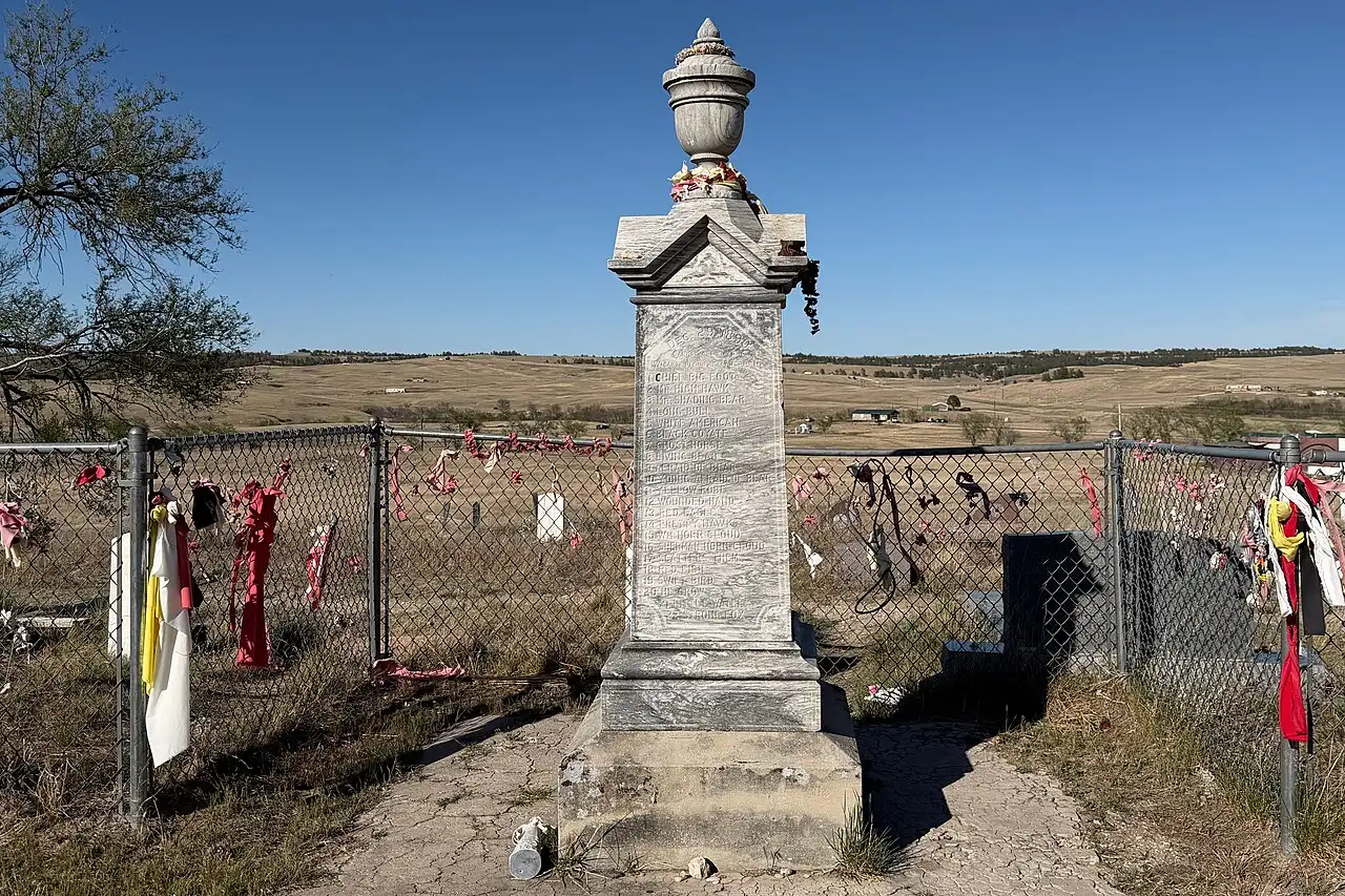 The Wounded Knee monument on the South Dakota prairie, draped with prayer ties