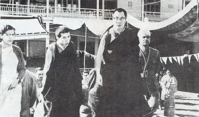 The young 14th Dalai Lama, wearing glasses, in India shortly after his 1959 escape from Tibet, walking with Indian officials