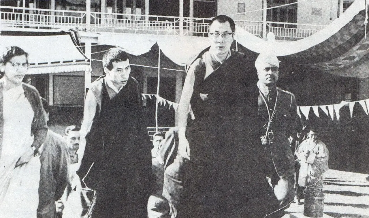 The young 14th Dalai Lama, wearing glasses, in India shortly after his 1959 escape from Tibet, walking with Indian officials
