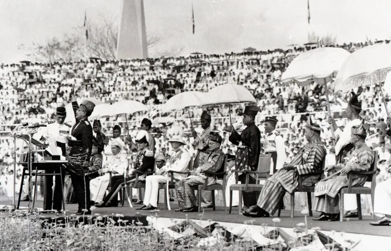 Tunku Abdul Rahman proclaiming Malaya's independence at Stadium Merdeka on August 31, 1957, before the Malay rulers and a crowd of thousands.