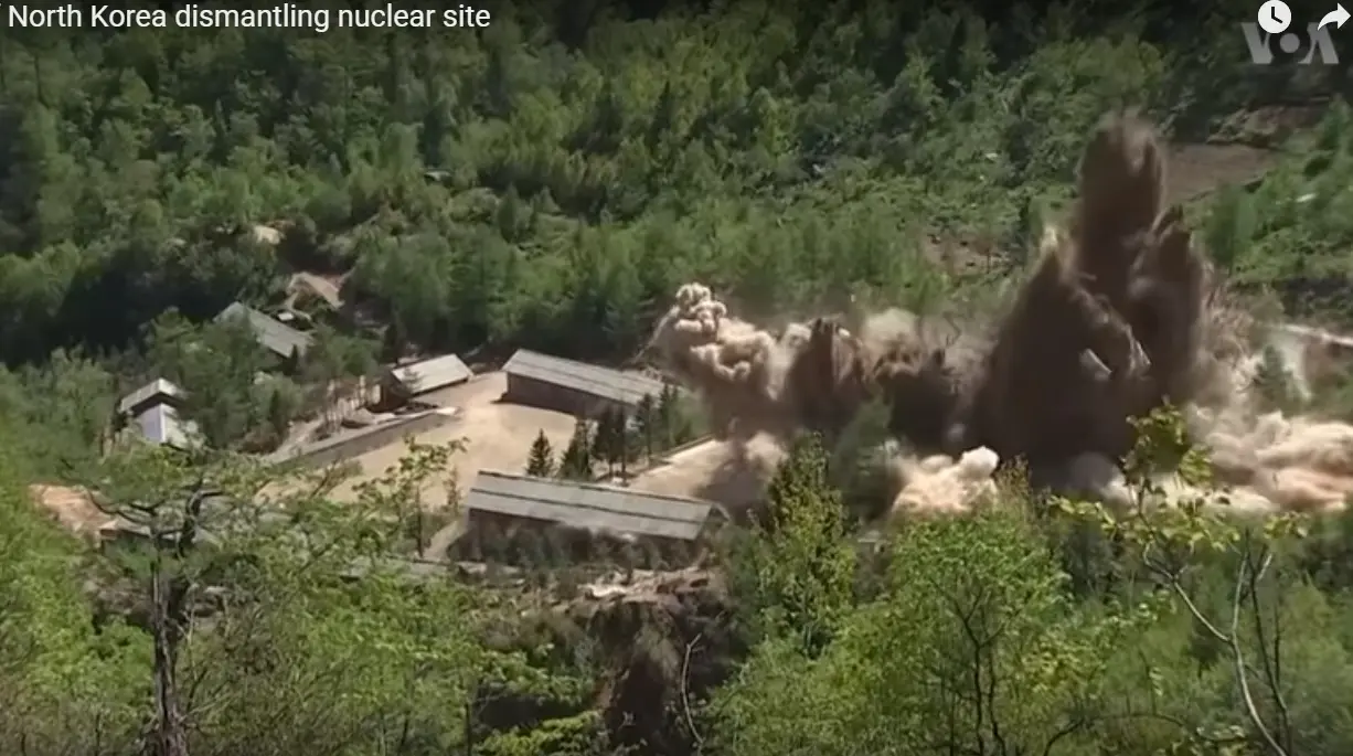 A video frame of the demolition of the Punggye-ri nuclear test site in 2018 — an explosion tearing apart buildings at the mountain tunnel complex where North Korea conducted its first nuclear test on October 9, 2006.