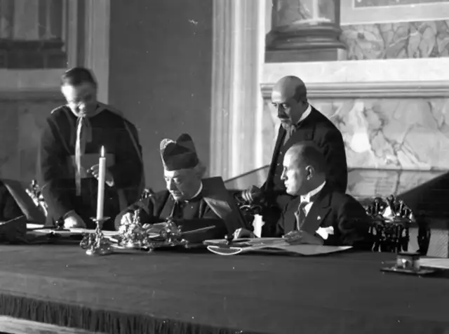 Cardinal Pietro Gasparri signs the Lateran Pacts as Benito Mussolini looks on, Rome, 11 February 1929